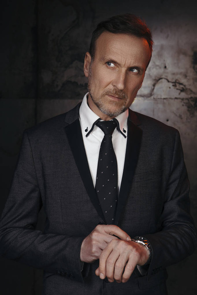 Old handsome business man in white shirt and tie on a grunge dark background - Photo, Image
