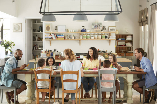 Two families having lunch together in the kitchen at home - Fotoğraf, Görsel