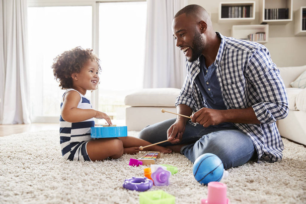 Young father playing with daughter in sitting room - Photo, image