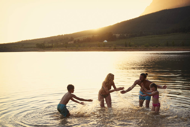Family Enjoying Evening Swim In Countryside Lake - Zdjęcie, obraz