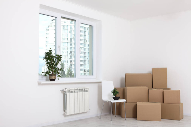 Moving into a new apartment. Move lots of cardboard boxes in an empty new apartment. - Photo, Image