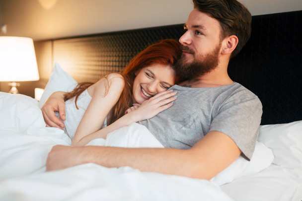 Happy couple in bed showing emotions and love - Fotografie, Obrázek
