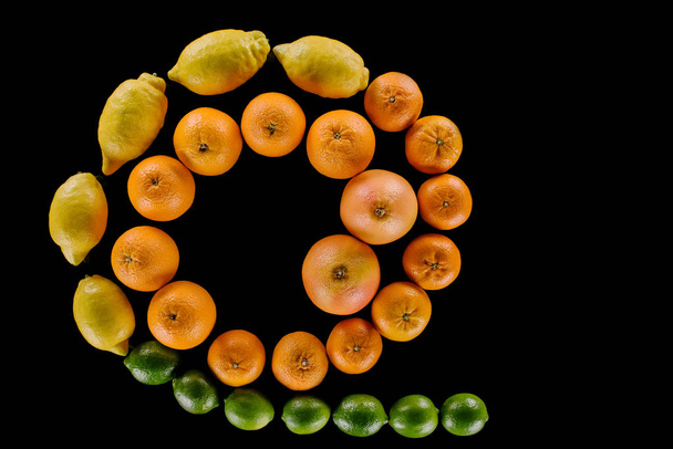 pohled shora složení různých čerstvých citrusových plodů do spirály izolované na černém pozadí - Fotografie, Obrázek