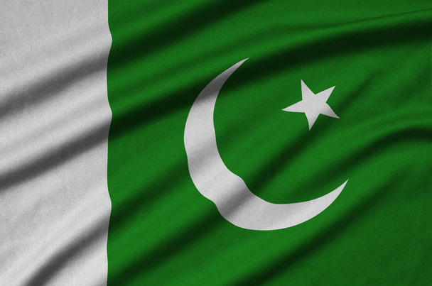 Pakistan flagi jest przedstawiony na materiał tkaniny sportowe z dużo chętnych. Transparent macha Sport team - Zdjęcie, obraz