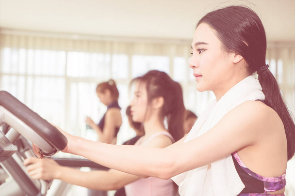 Mujer asiática está haciendo ejercicio en la máquina de gimnasio fitness
 - Foto, imagen