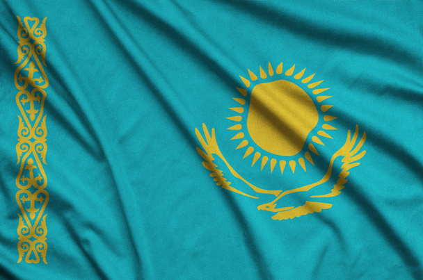カザフスタンの旗は多くの襞とスポーツの布生地に描かれています。スポーツ チームを振ってバナー - 写真・画像