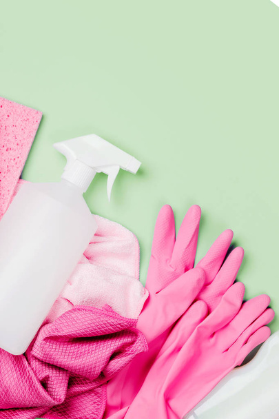 Detergents and cleaning accessories  in pink color.  Cleaning service concept. Flat lay, Top view. - Foto, afbeelding