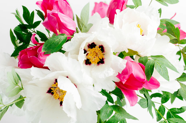 Beautiful bouquet of white peonies and pink tulips in a glass vase on a white background - Photo, Image
