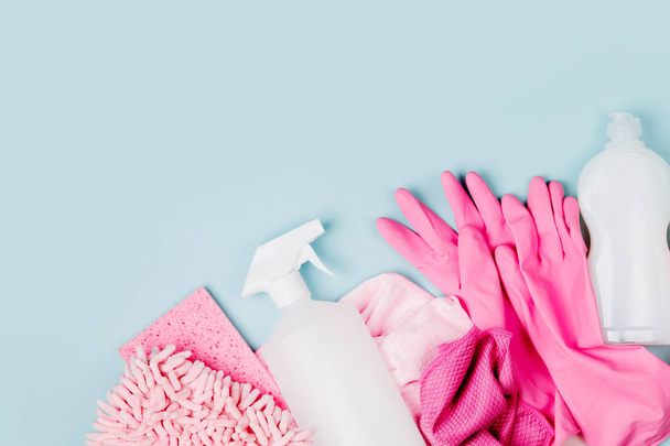 Detergents and cleaning accessories  in pink color.  Cleaning service concept. Flat lay, Top view. - Фото, зображення