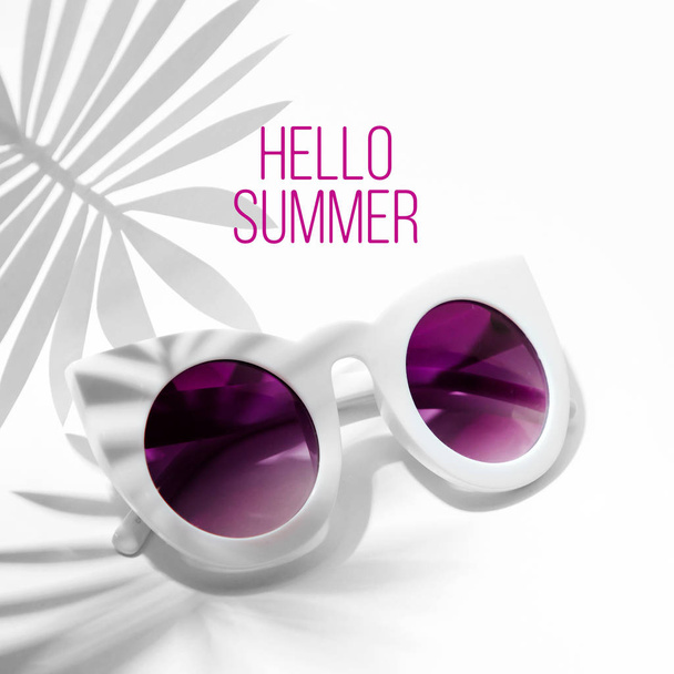Stylish sunglasses with bright sunlight and shadow from palm leaves. Summer vacation concept. - Zdjęcie, obraz