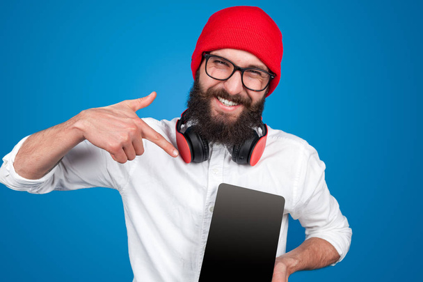 Man in headphones pointing at tablet - Φωτογραφία, εικόνα