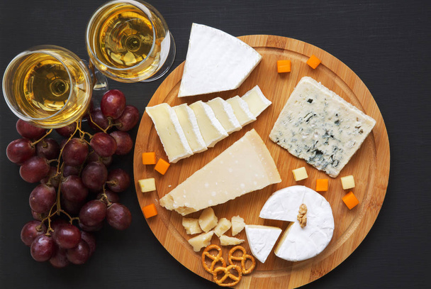 Şarap, simit, üzüm ve ceviz koyu arka plan üzerinde peynir tatma, görünümü top. Yiyecek şarap.  - Fotoğraf, Görsel