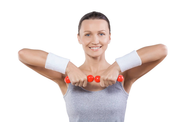 close up portrait sport woman with little red dumbbells looking  - Zdjęcie, obraz