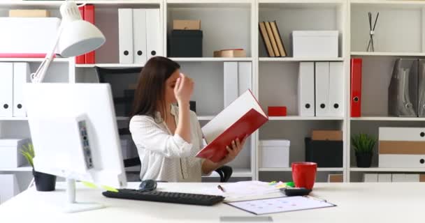 Geschäftsfrau in weißer Bluse liest Dokumente in Ordner - Filmmaterial, Video