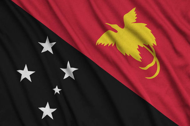 Papua New Guinea flag  is depicted on a sports cloth fabric with many folds. Sport team waving banner - Photo, Image