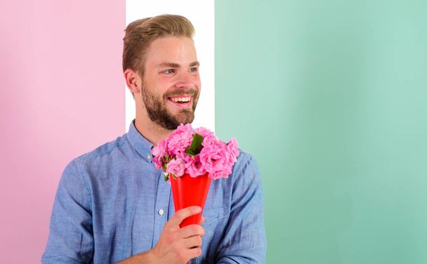Best flowers for her. Macho holds bouquet as romantic gift. Boyfriend happy holds bouquet waiting for date. Man ready for date bring pink flowers. Guy bring romantic pleasant gift waiting for her - Photo, Image