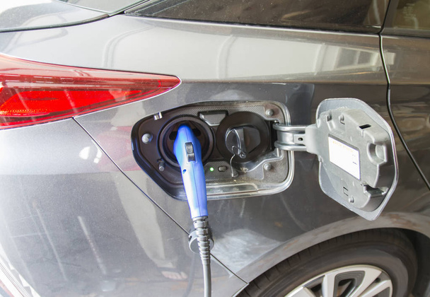 ein Elektroauto wird angeschlossen, um seine Batterie aufzuladen,  - Foto, Bild