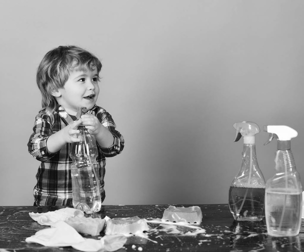 Parents little helper concept. Kid holds spray on table - Valokuva, kuva