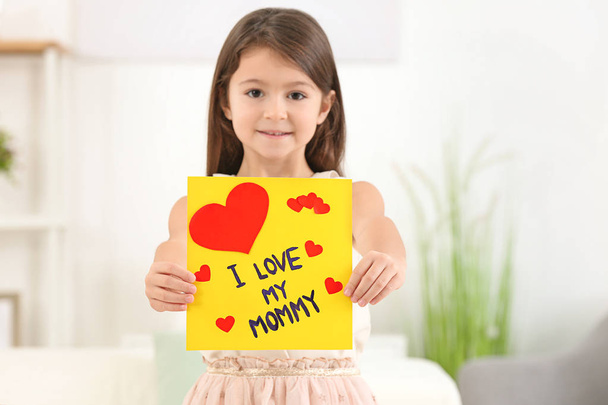 Little girl with greeting card for her mommy on Mother's Day indoors - Foto, Imagen