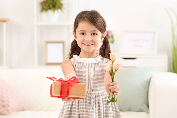 Little girl with gift and flowers for her mommy on Mother's Day indoors - Foto, Imagen