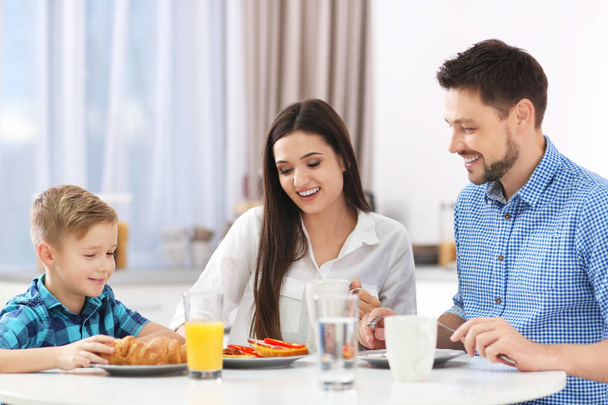 Happy family having breakfast together in kitchen - Фото, изображение