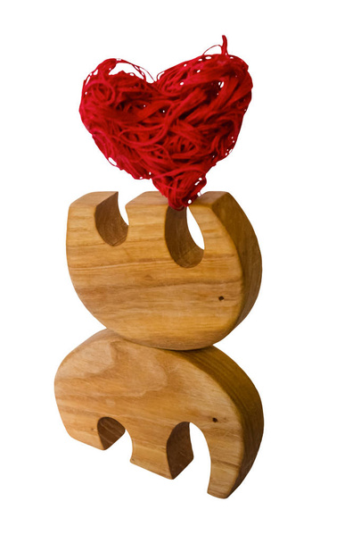 Elephant figurines support together a red decorative heart - Φωτογραφία, εικόνα