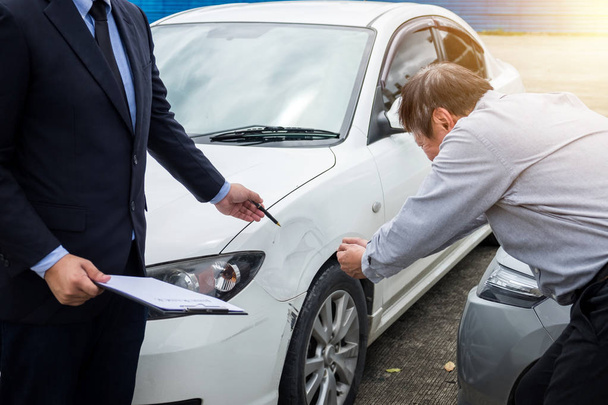 Insurance Agent examine Damaged Car and filing Report Claim Form after accident, Traffic Accident and insurance concept. - Photo, Image