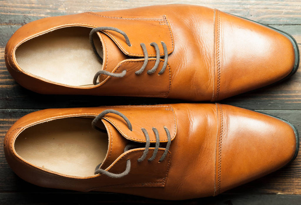 Men's leather shoes on a wooden floor - Фото, изображение