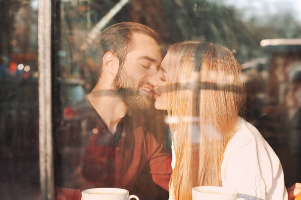 Young romantic couple in cafe, view from outdoors through window - Fotoğraf, Görsel