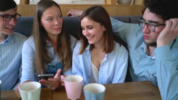 Young friends sit in a cafe, drink coffee and have fun communicating - Footage, Video