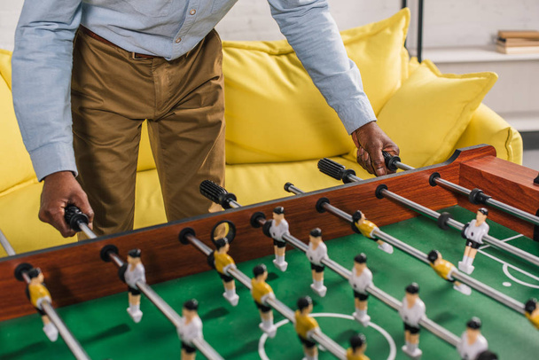 cropped shot of senior african american man playing table football at home - Фото, изображение