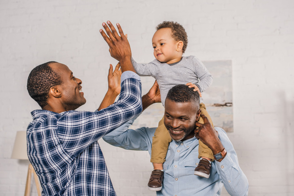 happy african american family having fun and giving high five at home - Fotoğraf, Görsel