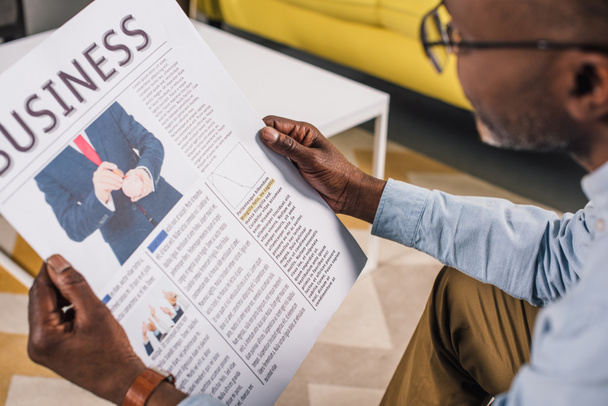 recortado disparo de mayor afroamericano hombre en gafas lectura de periódico de negocios
 - Foto, imagen