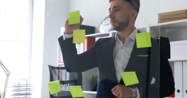businessman making notes in stickers on glass wall - Кадры, видео