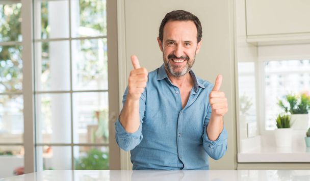 Красивый мужчина средних лет счастлив с большой улыбкой делает хорошо знак, большой палец вверх пальцами, отличный знак
 - Фото, изображение