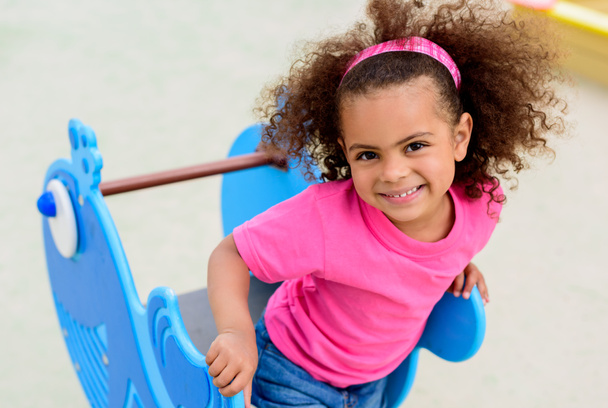 portrait of curly african american little child having at playground  - 写真・画像