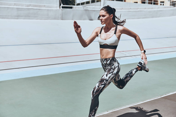 athlete woman in sports clothing jogging on stadium  - Fotografie, Obrázek
