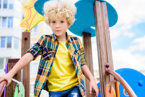 low angle view of adorable curly little boy having fun at playground  - Foto, Bild