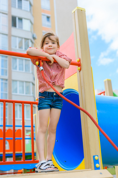 low angle view of adorable smiling kid looking at camera at playground  - Foto, immagini