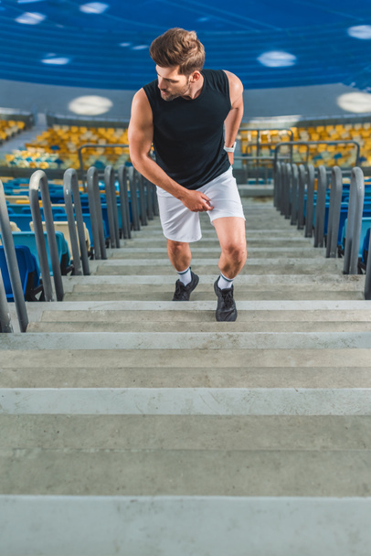 обрезанный снимок спортсмена бегущего по лестнице на спортивном стадионе
 - Фото, изображение