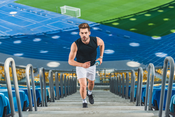 vue grand angle de jogging attrayant jeune homme à l'étage au stade de sport
 - Photo, image