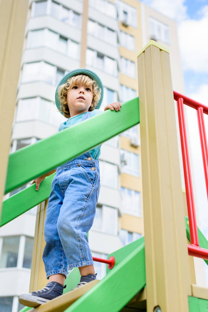 Tiefansicht eines kleinen Jungen in Panama, der auf einem Spielplatz die Treppe hinuntergeht  - Foto, Bild