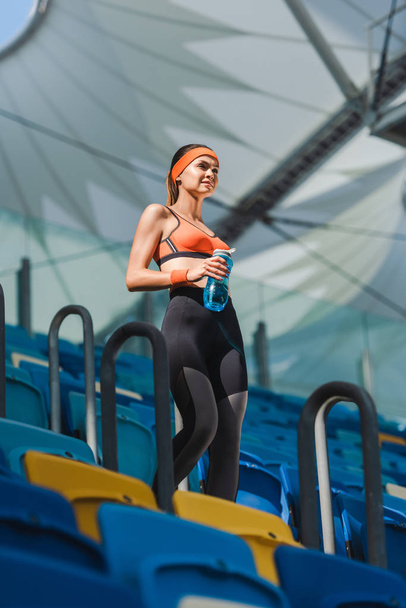 вид снизу красивой молодой женщины, идущей по лестнице на спортивном стадионе
 - Фото, изображение