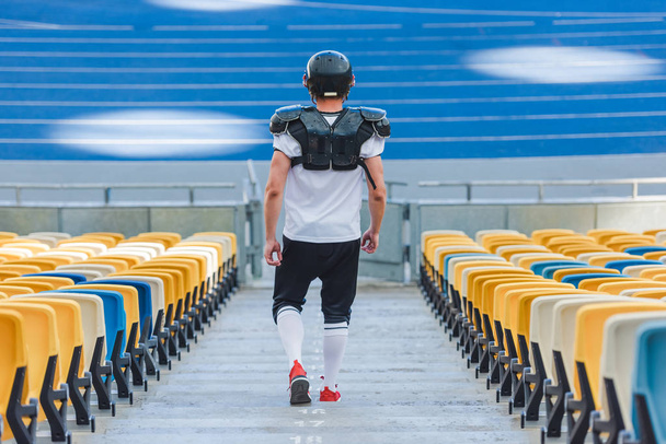 Widok z tyłu sprawny amerykański piłkarz na schodach na stadion sportowy - Zdjęcie, obraz