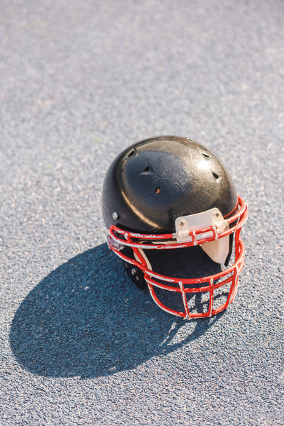 high angle view of american football helmet lying on asphalt - Foto, Imagen