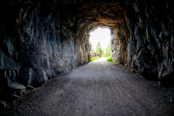 Luz al final del túnel en Myra Canyon en Kelonwa, Columbia Británica, Canadá. Concepto de conquistar la adversidad o el éxito a través de obstáculos
. - Foto, imagen