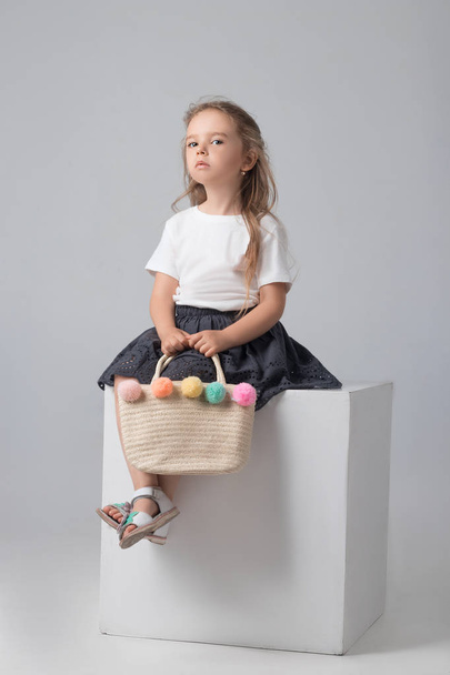 Stüdyoda poz bir hasır çanta ile kız - Fotoğraf, Görsel