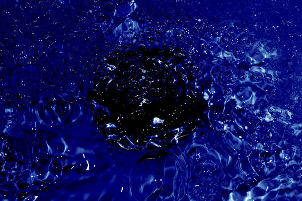 lavabo con scarico al centro della foto con acqua blu che scorre
 - Foto, immagini