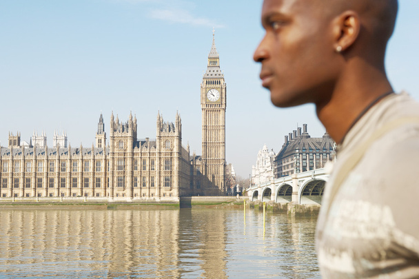 Vue large du palais de Westminster et de la Tamise avec un touriste qui passe devant
. - Photo, image