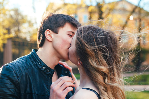Молодая пара влюбленных обнимает и целует на улице города
 - Фото, изображение